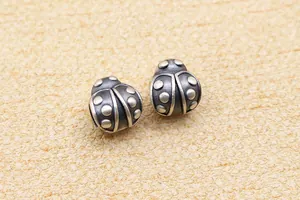 Makro-Detail von S999 Silber-Marienkäferperlen mit Antik-Finish für DIY-Schmuck
