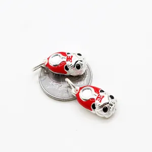 S925 sterling silver tiger pendant with red enamel design next to a coin for size reference