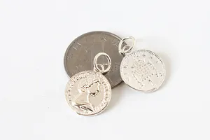 Détail macro du pendentif pièce Elizabeth II en argent 925 et emblème de blason