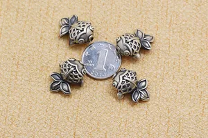 Detaillierte Makroansicht von vier antiken 999er Silber Karpfenperlen für DIY-Schmuck