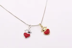 Gros plan de pendentifs cœur couronne en or et argent avec émail rouge et cristaux