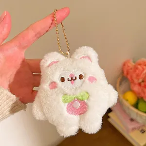 Détail d'un joli porte-clés lapin en peluche avec broderie rose et chaîne à boules dorée