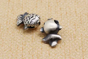 Makroansicht von 999 Feinsilber Koi-Fisch Perlen mit Antik-Finish und Reinheitsstempel