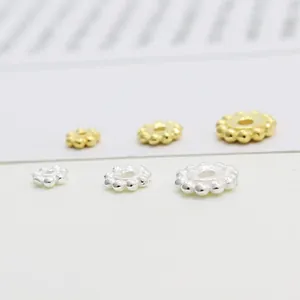 Vue macro des perles d'espacement en forme de fleur argent et or pour bijoux DIY
