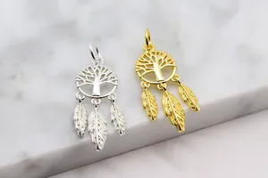 Macro detail of silver and gold tree of life dreamcatcher pendants with feather charms