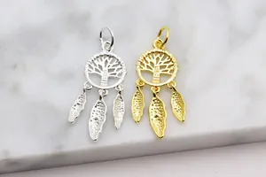 Detail of silver and gold tree of life dreamcatcher charms with hanging feather pendants