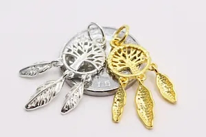 Detailed macro of gold and silver S925 dreamcatcher charms with tree and feather pendants