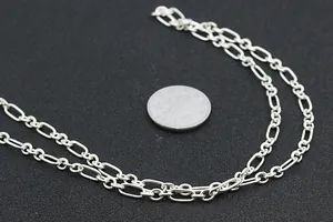 Macro view of S925 silver punk chain links next to a coin for size reference