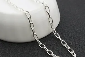 Gros plan des maillons rectangulaires polis en argent S925 sur de la porcelaine blanche