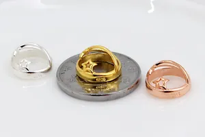 Macro shot of S925 sterling silver hollow star ring charms in silver, gold, and rose gold