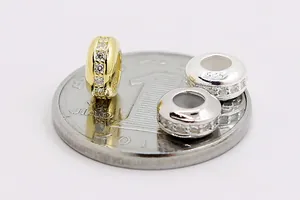 Macro shot of S925 sterling silver pave zircon charms on a coin for size reference