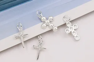 Macro shot of S925 sterling silver cross pendants in polished bead and thorn designs