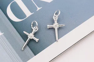 Macro shot of S925 sterling silver nail-shaped cross pendants with engraved hallmarks