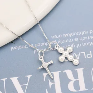 Polished S925 sterling silver cross pendants on a box chain over a blue background