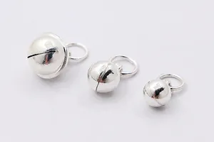 Close-up of three sizes of silver-plated copper bells for DIY jewelry making