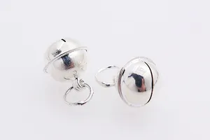 Macro shot of two polished silver bell pendants with ringing sound for DIY jewelry making