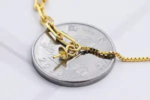 Gros plan détaillé des maillons de bracelet en argent S925 doré près d'une pièce témoin