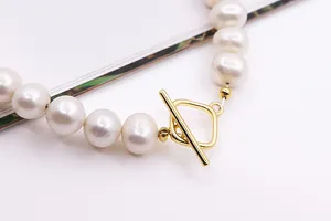 Macro view of a gold square OT toggle clasp on a string of white freshwater pearls