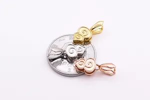 Detalle macro de colgantes de plata S925 con motivos de nubes y moneda para escala