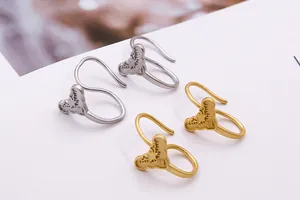 Makroansicht matter gold- und silberner Ohrhaken mit geprägten Sternen im Vintage-Stil