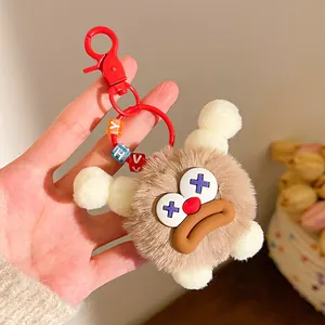 Macro detail of brown plush keychain with funny expression and colorful letter beads