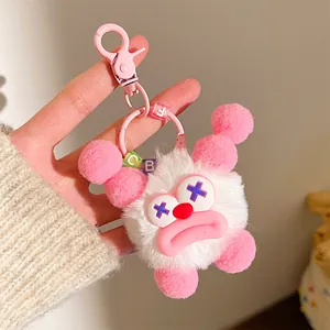 Close-up of cute plush monster keychain with fuzzy fur and pink sausage lips detail