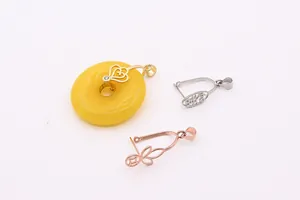 Macro detail of S925 silver pendant clasps and heart-shaped amber stone attachment