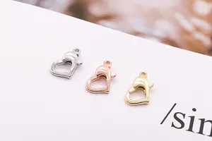Dettaglio macro di chiusure a moschettone a cuore in argento, oro e oro rosa