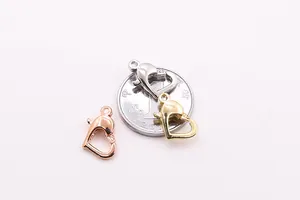 Vista macro di chiusure a moschettone a cuore in argento S925 oro, argento e oro rosa