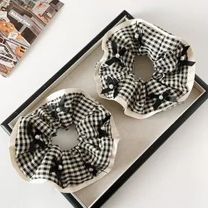 Lot de deux chouchous à carreaux avec nœuds noirs et perles sur plateau vintage