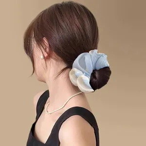 Blue and white gradient organza scrunchie shown on a low bun hairstyle in back view