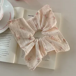 Chouchou à fleurs printanières posé sur un livre et une tasse de café élégante