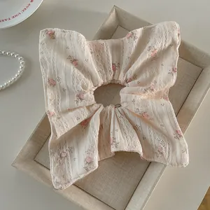 Gros plan détaillé d'un chouchou en dentelle florale avec motifs roses sur plateau