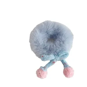Cute blue plush hair tie with knitted bow and pink fuzzy pom-poms for winter styles