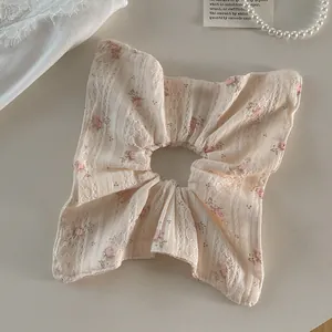 Gros plan d'un chouchou géant en dentelle aux motifs de fleurs roses délicates
