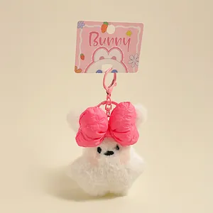 Porte-clés lapin en peluche blanc avec nœud rose et fermoir en métal sur carte