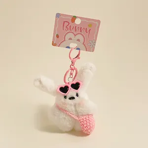 Détail du porte-clés lapin en peluche blanc avec sac rose et lunettes de soleil coeur