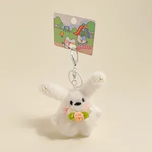 Détail du porte-clés lapin en peluche blanche avec oreilles perlées et rose en satin