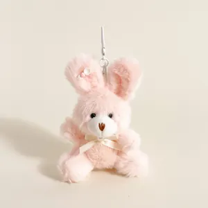 Détail du pendentif lapin en peluche rose avec un nœud en soie crème et un crochet de fixation