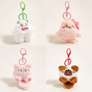 Set van vier schattige pluizige monster pluche sleutelhangers in wit, roze en bruin met haken