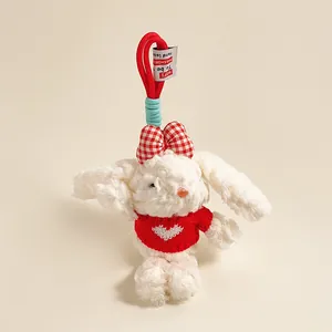 Detail van een witte pluche konijn met rood geblokte strik en gebreide hartjestrui