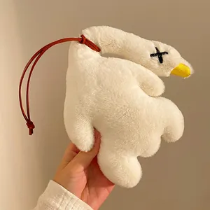 Close-up of white plush duck keychain with fluffy texture and leather strap detail