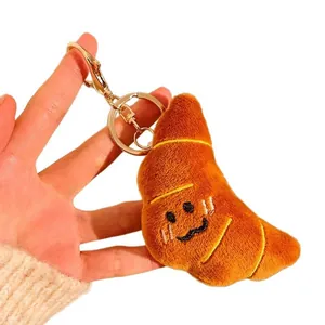 Porte-clés croissant en peluche avec visage souriant et fermoir mousqueton en métal doré