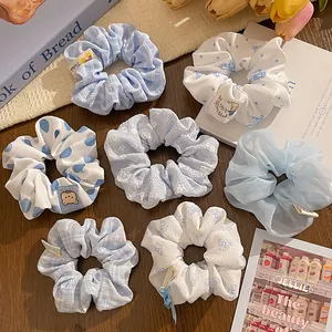 Set of 7 blue and white scrunchies with polka dots, plaid patterns and lace details