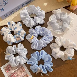 Detailed set of blue and white polka dot scrunchies with lace and ribbon accents
