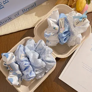 Detail of blue and white polka dot scrunchie set in a gift box with floral patterns