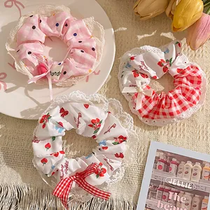 Detail of assorted blue polka dot and strawberry scrunchies with white lace edges