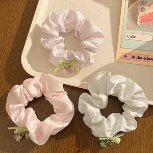 Detailed view of floral hair scrunchies set with silk bows and flower pendants