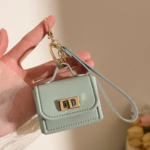 Dettaglio mini borsa portachiavi verde menta con chiusura dorata e trama in pelle PU