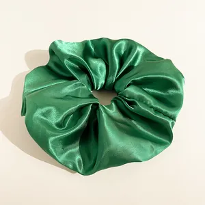 Dettaglio dell'elastico in raso verde smeraldo con tessuto lucido e trama a pieghe